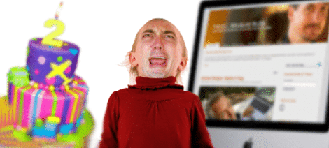 Image: A man in a red shirt appears distressed with an exaggerated frown, standing beside a cake with a lit "terrible twos" candle. Behind him is a computer screen displaying a LinkedIn profile. -- D.C. Douglas