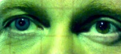 Image: Close-up of a person's eyes, showing detailed textures of the skin and intense gaze. The image portrays a striking and expressive look with focus on the eyes in "Apocalypse Kiss. -- D.C. Douglas