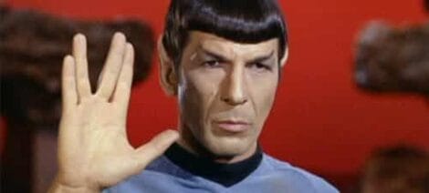 Image: A character exemplifying the Spock archetype, with a Vulcan salute, short black hair, and raised eyebrows, sporting a serious expression. He is dressed in a blue uniform against a red background. -- D.C. Douglas