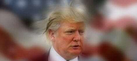 Image: Blurred image of a man with light-colored hair and fair skin, slightly out of focus, standing proudly with an American flag visible in the background. -- D.C. Douglas