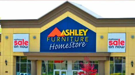 Top 5 Best Commercials Of 2025 | D.c. Douglas Exterior view of the Ashley Furniture Homestore with a blue and yellow facade and signage.