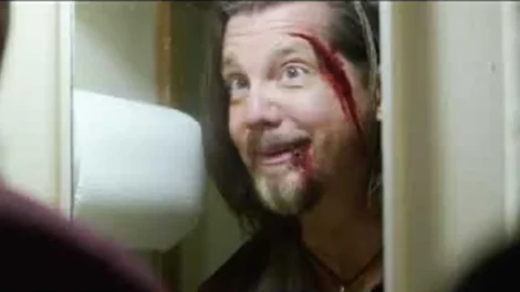 A man with a bloodied face and a surprised expression standing in a bathroom doorway.