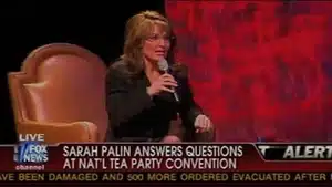 Sarah Palin speaking into a microphone at the National Tea Party Convention event.