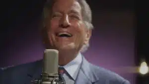 Top 5 Best Commercials Of 2025 | D.c. Douglas A man with gray hair laughing while singing into a microphone in a studio setting.