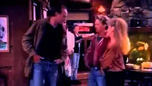 Three characters interacting in a scene from a television show, with one man and two women.