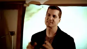 Gadfly: Breaking News &Amp; Tweaked Nipples | D.c. Douglas A man gesturing while speaking in front of a light-colored backdrop.