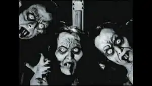Three distorted faces with pale skin and exaggerated features, displaying eerie expressions and dark makeup.