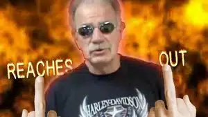 Gadfly: Breaking News &Amp; Tweaked Nipples | D.c. Douglas Man wearing sunglasses and a Harley Davidson t-shirt, making a gesture with his hands.