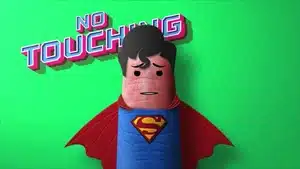 Cartoon superhero character with a blue costume and red cape, standing against a green background with a 'No Touching' sign.