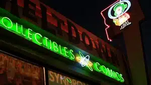 Neon signage displaying 'Collectibles' and 'Comics' at a storefront with bright lights.