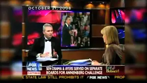 Two television news anchors discussing a topic on set with a background image of a political event.