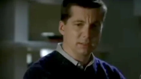 A man wearing a dark sweater with a concerned expression on his face, looking slightly to the side.